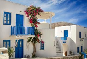 ein weißes Gebäude mit blauen Türen und Blumen darauf in der Unterkunft Meltemi in Folegandros Chora