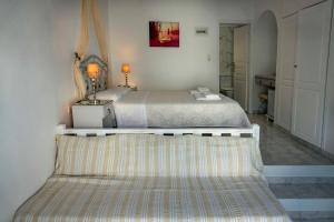 a bedroom with a bed with a bench in it at Meltemi in Chora Folegandros