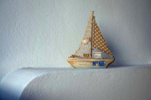 a small wooden sail boat on a wall at Meltemi in Chora Folegandros
