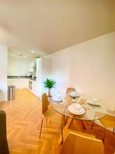 uma sala de jantar com uma mesa de vidro e cadeiras em 2 Double beds OR 4 Singles, 2 Bathrooms, FREE PARKING, Smart TV's, Close to Gunwharf Quays, Beach & Historic Dockyard em Portsmouth