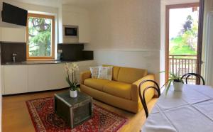 sala de estar con sofá amarillo y cocina en Casa del Pittore, en Rovereto