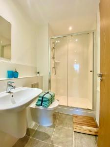 ein Bad mit einer Dusche, einem WC und einem Waschbecken in der Unterkunft 2 Double beds OR 4 Singles, 2 Bathrooms, FREE PARKING, Smart TV's, Close to Gunwharf Quays, Beach & Historic Dockyard in Portsmouth