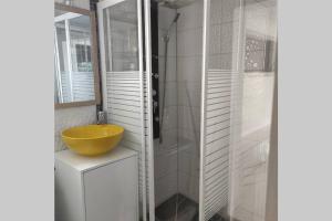 勒马兰Studio lumineux vue exceptionnelle sur la mer的浴室配有黄色水槽和淋浴。