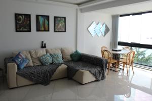 ein Wohnzimmer mit einem Sofa und einem Tisch in der Unterkunft Porto Real Resort - Apto 3 Suites Vista para o Mar in Mangaratiba