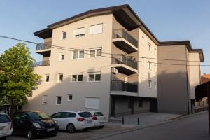 a building with cars parked in front of it at Exclusive apartment Visoko in Visoko