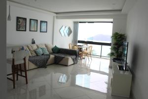 Porto Real Resort - Apto 3 Suites Vista para o Mar في مانغاراتيبا: غرفة معيشة مع أريكة وطاولة
