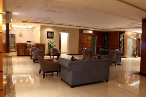 a waiting room with couches and chairs in a lobby at أمارا سويتس in Dammam