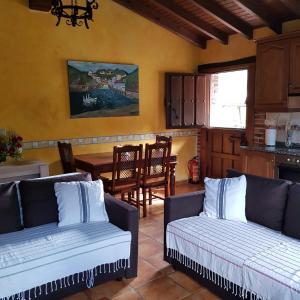 a living room with two couches and a table at Carroceu Rural in Cangas de Onís