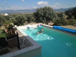 a person is in a swimming pool in a swimming pool at La Casona de Requijada a 6km de Pedraza con Piscina in Requijada