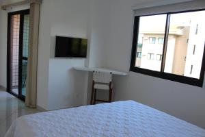a white bedroom with a bed and a tv on the wall at Porto Real Resort - Apto 3 Suites Vista para o Mar in Mangaratiba +63 photos