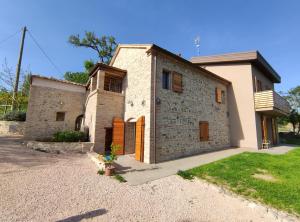 a large stone house with a yard at Mulino Vigoli in Morciano di Romagna