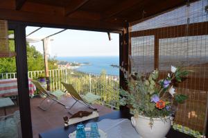 - un balcon avec un vase de fleurs offrant une vue sur l'océan dans l'établissement LA CASTELLANA Una Finestra sul Mare- Air Conditioned, à Lerici