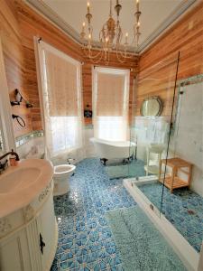 a bath room with a tub, sink, and toilet at The Artist House in Key West