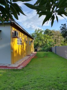 ein gelbes und weißes Haus mit einem Hof in der Unterkunft Ultimate Freedom Bed and Breakfast in Santa Cruz