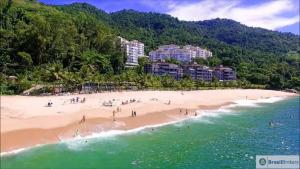 a group of people on a beach near the water at Porto Real Resort - Apto 3 Suites Vista para o Mar in Mangaratiba