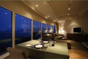 a living room with a table and a couch at Hotel Neu Schloss Otaru in Otaru