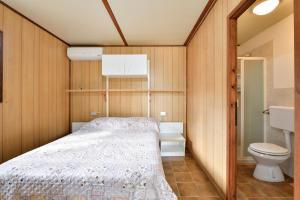 Dormitorio pequeño con cama y aseo en Villaggio Camping Tesonis Beach, en Tertenìa