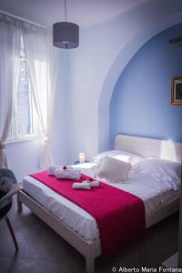 una camera da letto con un letto grande con una coperta rossa di Residenza Florida a Noli