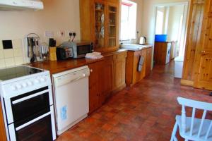 a kitchen with white appliances and wooden cabinets at Sporting Lodge Shanagolden in Limerick