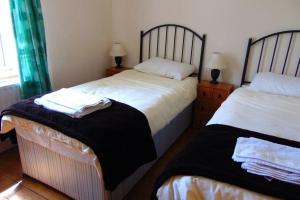 um quarto com duas camas com saias em Sporting Lodge Shanagolden em Limerick