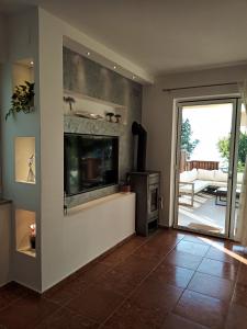 een woonkamer met een flatscreen-tv aan de muur bij apartman Emili in Malinska