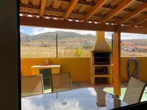 a patio with a table and chairs and a fireplace at Cantinho Solpraia in Porto Santo