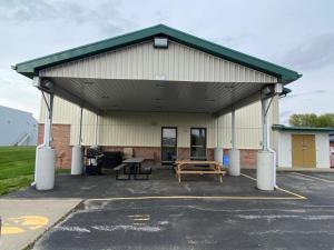 ein großes Gebäude mit einem Picknicktisch auf einem Parkplatz in der Unterkunft wallaceburg inn in Wallaceburg