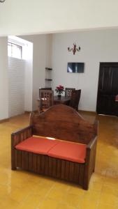 Cama de madera en habitación con mesa en Casa Gaby en Morelia