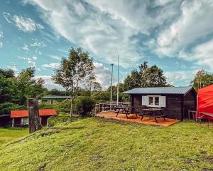 a cabin with a picnic table and a red tent at Pruuli Puhkeküla in Nurme