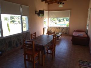 ein Esszimmer mit einem Tisch, Stühlen und einem Bett in der Unterkunft Cabañas Calihue in Tandil