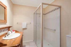 a bathroom with a shower and a sink at Pelican Lake Holiday House in Merimbula +27 photos