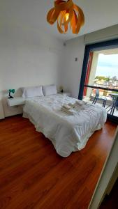 Un dormitorio con una gran cama blanca y una ventana en 1 dormitorio - zona Pichincha - Nuevo en Rosario