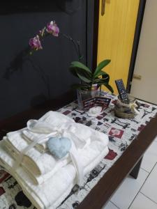 una mesa con toallas y un jarrón con una flor en Affittacamere da chris, en Reggio Calabria