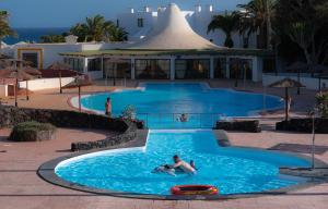 un paio di persone in una piscina di Apartamento Norma 8 Playa Roca a Costa Teguise