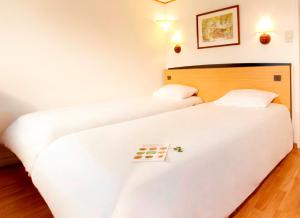 two beds in a hotel room with a chess board at Campanile Calais in Calais +25 photos