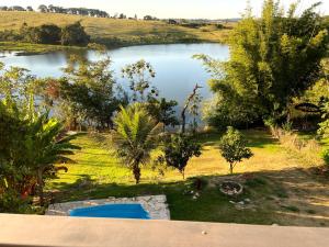 Utsikt mot bassenget på Casa com piscina fundo pra represa e AR Condicionado CasinhaBrancaDeVaranda eller i nærheten