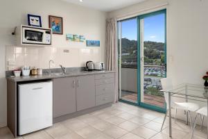 eine Küche mit einer Spüle und einer Mikrowelle in der Unterkunft Parkhill Accommodation in Whangarei