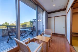 Habitación con balcón con mesa y sillas. en Miyako Resort Okushima Aqua Forest (Hotel Kintetsu Aqua Villa Ise Shima), en Shima