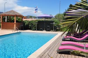 uma piscina com cadeiras e um gazebo em Hôtel de la Vierge Noire em Sainte-Maxime