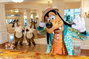 a group of people dressed in costumes in a lobby at Hong Kong Disneyland Hotel in Hong Kong