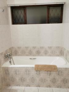 a white bath tub in a bathroom with a window at Stella Maris 123 in Amanzimtoti