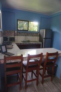 a kitchen with a table and two wooden chairs at Casitas Joys & Leo - Tucan in Santa Rita