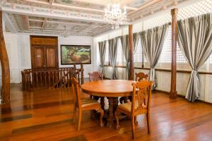 a dining room with a wooden table and chairs at Las Casas Filipinas de Acuzar in Bagac