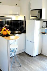 a kitchen with a table and a white refrigerator at STUDIO'MARCEL in Blagnac