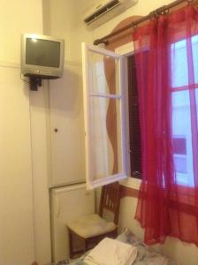 a room with a window and a tv and a window at Niki Rooms in Tinos Town