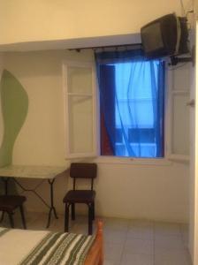 ティノス・タウンにあるNiki Roomsのベッドルーム1室(ベッド1台付)、窓(テレビ付)
