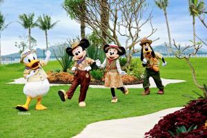 香港にあるディズニー エクスプローラーズ ロッジの公園を歩く不気味な人々