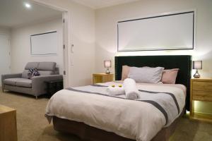 a bedroom with a bed with two stuffed animals on it at Am I in Heaven? Luxury 3 ensuite bedrooms sleeps 8 in Greymouth