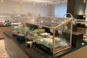 a display case in a kitchen with some food at Shizutetsu Hotel Prezio Kyoto Shijo in Kyoto