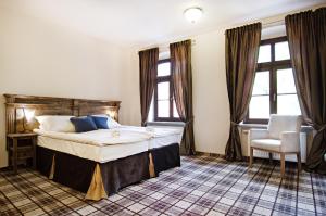 a bedroom with a large bed and two windows at Five Stars Bed&Breakfast in Wrocław